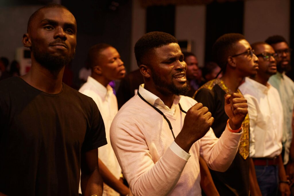 A group of men passionately participating in a worship ceremony indoors.